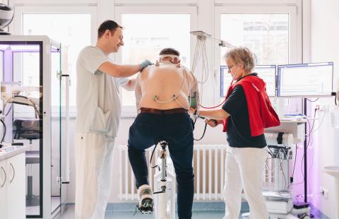 Sportmedizin Headerbild: Untersuchung auf dem Ergometer mit mit Pfleger und Ärztin.