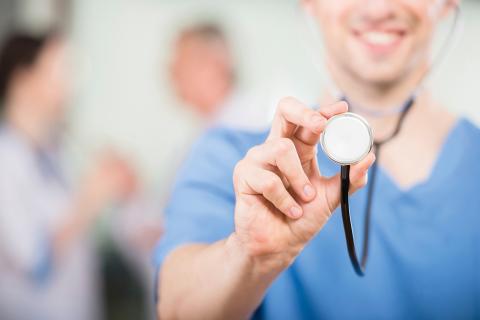 MVZ Forum Gesundheit Dresden, Fachbereich für Diabetologie und Stoffwechselmedizin, vorläufiges Headerbild: Stethoskop im Vordergrund einer Ärztin oder eines der Arztes, der/die es dem Betrachter entgegen hält als Symbol für Innere Medizin.